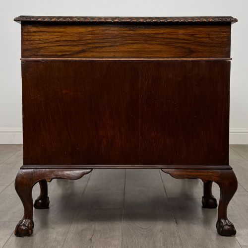 fig 2. An antique oak pedestal desk featuring twin drawer pedestals, carved borders, and cabriole legs terminating in ball-and-claw feet.