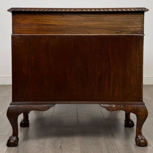 fig 6. An antique oak pedestal desk featuring twin drawer pedestals, carved borders, and cabriole legs terminating in ball-and-claw feet.