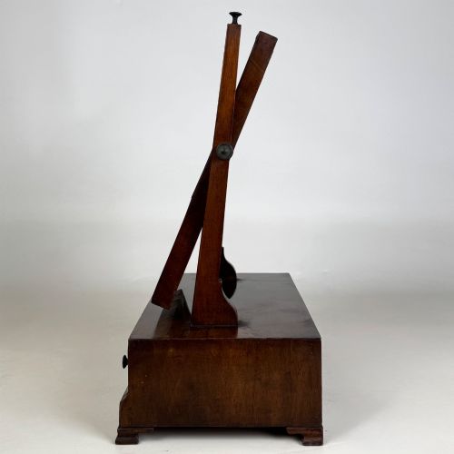 fig 1. An 18th-century Georgian mahogany dressing mirror featuring an adjustable rectangular tilting glass plate supported above a shaped box base containing three small drawers.