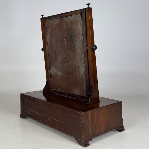 fig 5. An 18th-century Georgian mahogany dressing mirror featuring an adjustable rectangular tilting glass plate supported above a shaped box base containing three small drawers.
