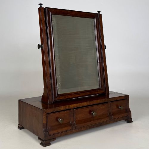 fig 8. An 18th-century Georgian mahogany dressing mirror featuring an adjustable rectangular tilting glass plate supported above a shaped box base containing three small drawers.
