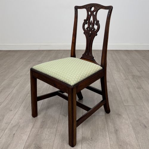 fig 1. A set of six Georgian mahogany dining chairs featuring intricate carved pierced splat backs, square legs, and light green patterned upholstered seats.