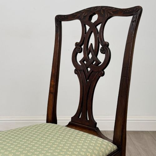 fig 3. A set of six Georgian mahogany dining chairs featuring intricate carved pierced splat backs, square legs, and light green patterned upholstered seats.