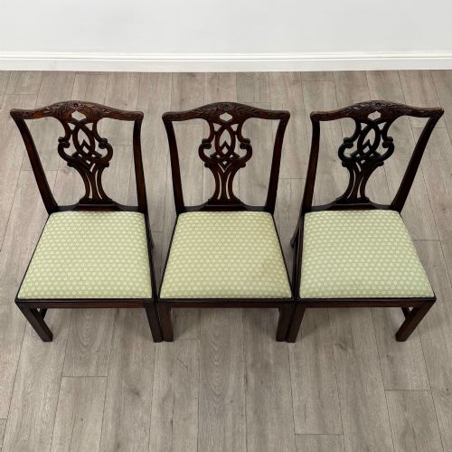 fig 6. A set of six Georgian mahogany dining chairs featuring intricate carved pierced splat backs, square legs, and light green patterned upholstered seats.