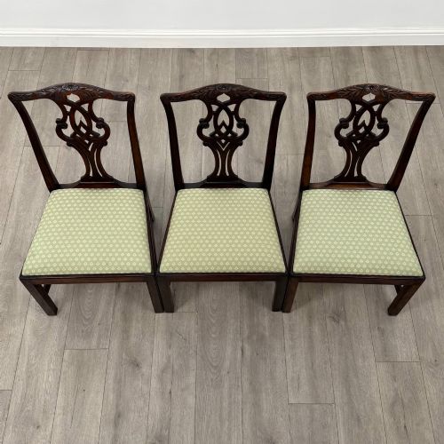 fig 7. A set of six Georgian mahogany dining chairs featuring intricate carved pierced splat backs, square legs, and light green patterned upholstered seats.