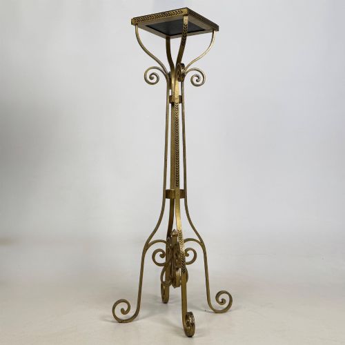 fig 4. A pair of tall gilded metal plant stands featuring incised leaf patterning, scrollwork legs, and square dark marble tops.