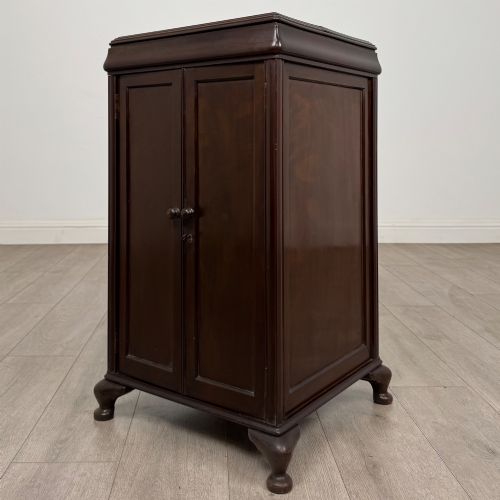 fig 2. An early 20th-century dark mahogany cupboard featuring two panelled doors with small wooden turned knobs, keyhole escutcheon, and cabriole feet.