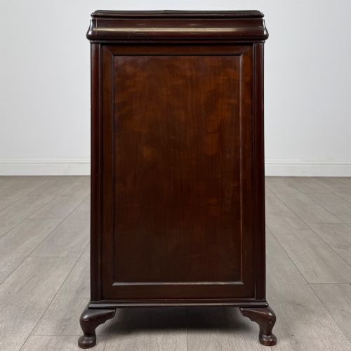 fig 3. An early 20th-century dark mahogany cupboard featuring two panelled doors with small wooden turned knobs, keyhole escutcheon, and cabriole feet.