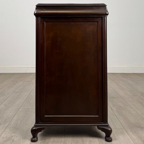 fig 7. An early 20th-century dark mahogany cupboard featuring two panelled doors with small wooden turned knobs, keyhole escutcheon, and cabriole feet.
