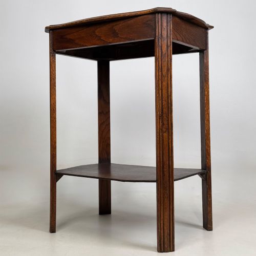 fig 1. An Edwardian dark oak side table featuring fluted legs, a moulded top, and a lower shelf tier.