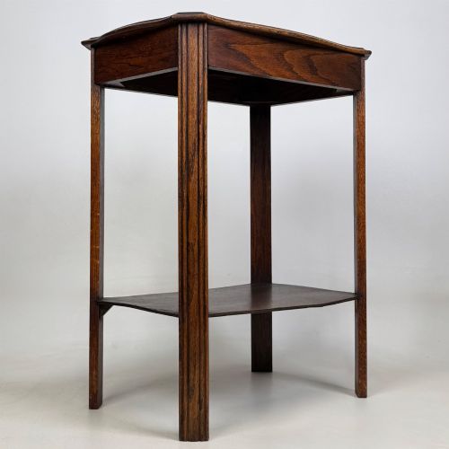 fig 7. An Edwardian dark oak side table featuring fluted legs, a moulded top, and a lower shelf tier.