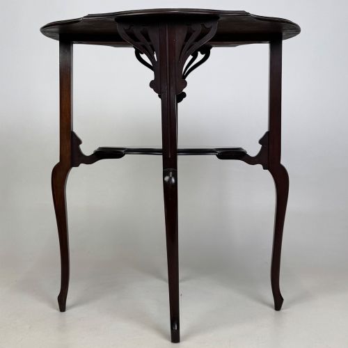 fig 3. An Edwardian dark mahogany side table featuring a shaped top, pierced carved spandrels, slender cabriole legs, and a lower tier shelf.