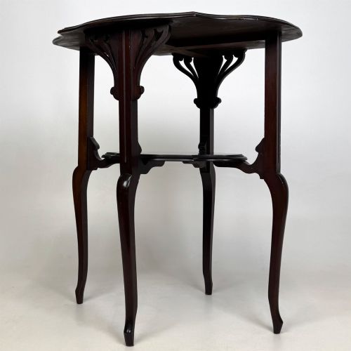 fig 4. An Edwardian dark mahogany side table featuring a shaped top, pierced carved spandrels, slender cabriole legs, and a lower tier shelf.
