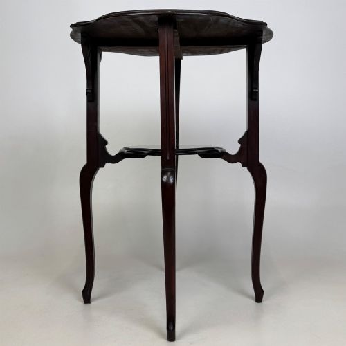 fig 5. An Edwardian dark mahogany side table featuring a shaped top, pierced carved spandrels, slender cabriole legs, and a lower tier shelf.
