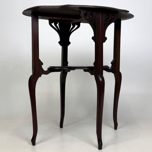 fig 6. An Edwardian dark mahogany side table featuring a shaped top, pierced carved spandrels, slender cabriole legs, and a lower tier shelf.