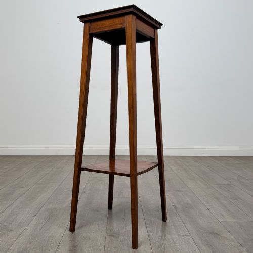 fig 3. A tall, slender Edwardian satinwood plant stand with square tapered legs, a flat square top, and a lower undertier shelf.