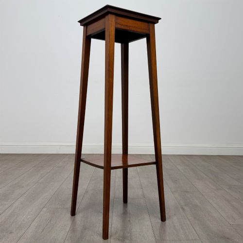 fig 5. A tall, slender Edwardian satinwood plant stand with square tapered legs, a flat square top, and a lower undertier shelf.