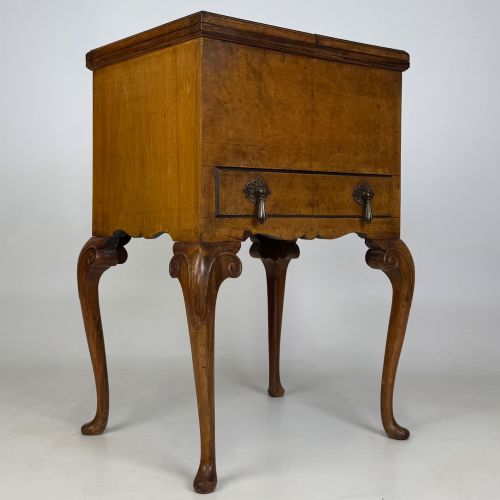 fig 7. An Edwardian burr walnut cabinet resting on slender cabriole legs with ornate brass drop handles.