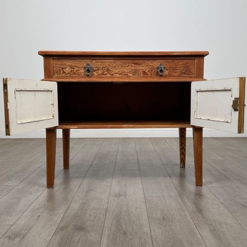 fig 1. A Victorian pitch pine cupboard featuring a single top drawer over two cupboard doors with diagonal timber panels and straight tapered legs.