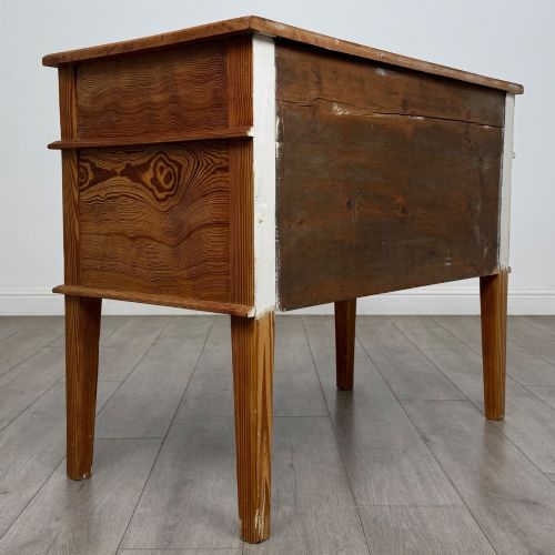 fig 4. A Victorian pitch pine cupboard featuring a single top drawer over two cupboard doors with diagonal timber panels and straight tapered legs.
