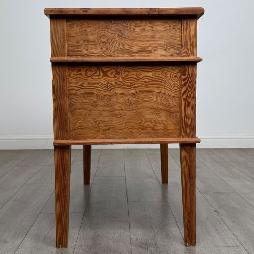 fig 7. A Victorian pitch pine cupboard featuring a single top drawer over two cupboard doors with diagonal timber panels and straight tapered legs.