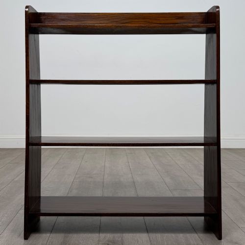 fig 1. A dark oak Edwardian open bookcase with four horizontal shelves holding leather-bound books.