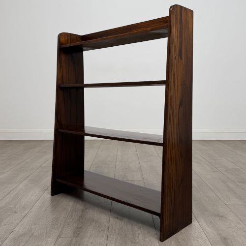 fig 2. A dark oak Edwardian open bookcase with four horizontal shelves holding leather-bound books.