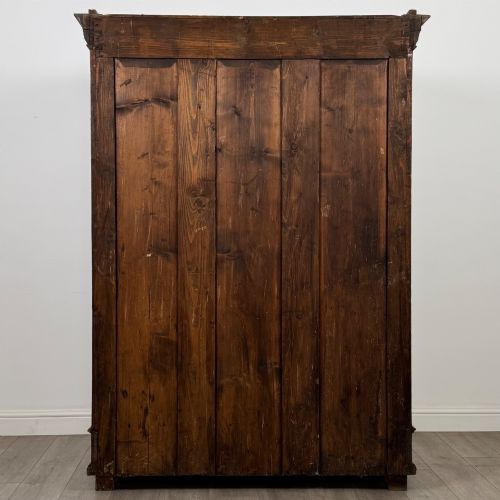 fig 5. A 19th-century French walnut wardrobe with double doors featuring detailed carved foliate panels, central fluted columns, two lower drawers, and a stepped cornice.