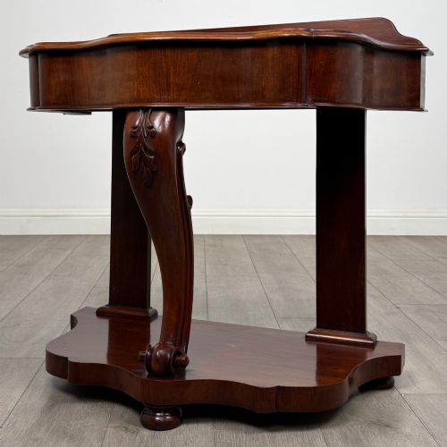 fig 1. A 19th-century Victorian mahogany washstand featuring a carved central leg, shaped top, and contoured plinth base.
