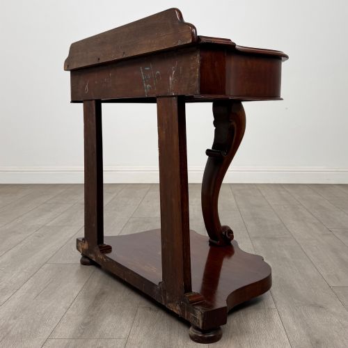 fig 5. A 19th-century Victorian mahogany washstand featuring a carved central leg, shaped top, and contoured plinth base.