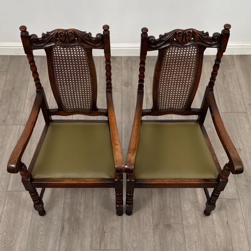 fig 7. A set of six Victorian oak dining chairs featuring carved crest rails, cane backrest panels, turned legs, and green upholstered seats.
