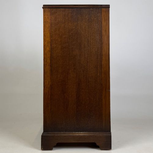 fig 3. A standing antique dark oak bedside cabinet with a single framed door, a round carved handle, and a solid plinth base.