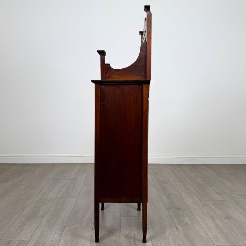 fig 3. An Edwardian mahogany display cabinet featuring a upper mirrored rail with floral wood inlay above a single glazed door cupboard.