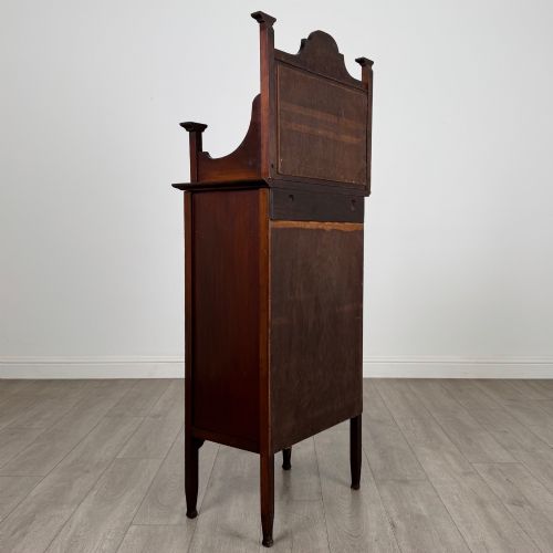 fig 4. An Edwardian mahogany display cabinet featuring a upper mirrored rail with floral wood inlay above a single glazed door cupboard.
