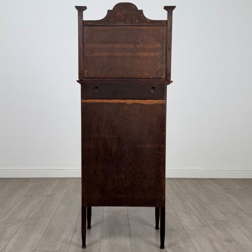fig 5. An Edwardian mahogany display cabinet featuring a upper mirrored rail with floral wood inlay above a single glazed door cupboard.
