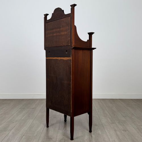fig 6. An Edwardian mahogany display cabinet featuring a upper mirrored rail with floral wood inlay above a single glazed door cupboard.