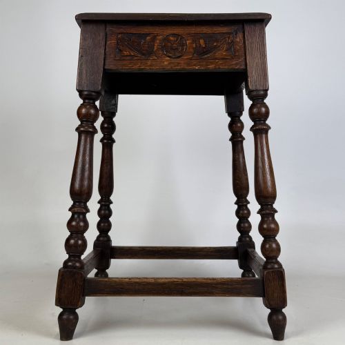 fig 6. An antique dark oak side table featuring carved rosette apron details, turned legs, and lower stretchers.
