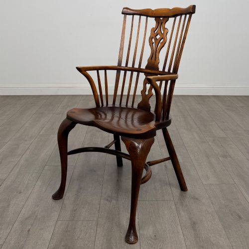 fig 1. A pair of warm brown elm Windsor armchairs featuring shaped top rails, pierced back splats, spindle supports, shaped saddle seats, and front cabriole legs.