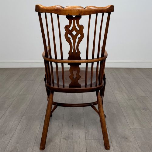 fig 4. A pair of warm brown elm Windsor armchairs featuring shaped top rails, pierced back splats, spindle supports, shaped saddle seats, and front cabriole legs.