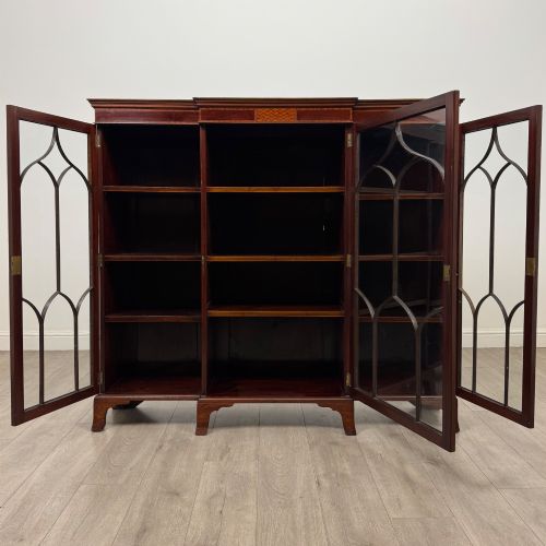 fig 1. A Victorian mahogany breakfront display cabinet with three astragal glazed doors featuring gothic arch tracery and top frieze inlay.