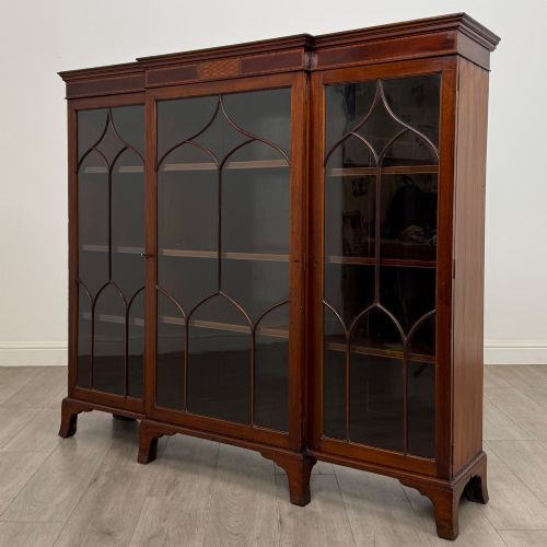 fig 2. A Victorian mahogany breakfront display cabinet with three astragal glazed doors featuring gothic arch tracery and top frieze inlay.