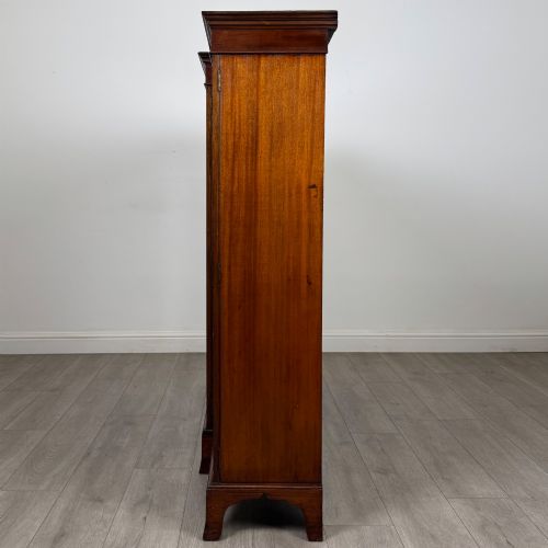 fig 3. A Victorian mahogany breakfront display cabinet with three astragal glazed doors featuring gothic arch tracery and top frieze inlay.