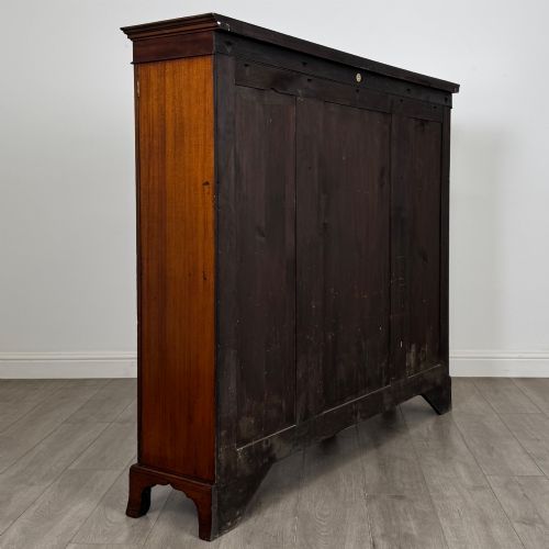 fig 4. A Victorian mahogany breakfront display cabinet with three astragal glazed doors featuring gothic arch tracery and top frieze inlay.