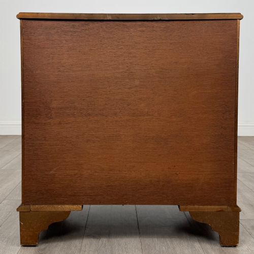 fig 4. A mahogany serpentine-front chest of drawers featuring four graduated drawers with brass handles and bracket feet.