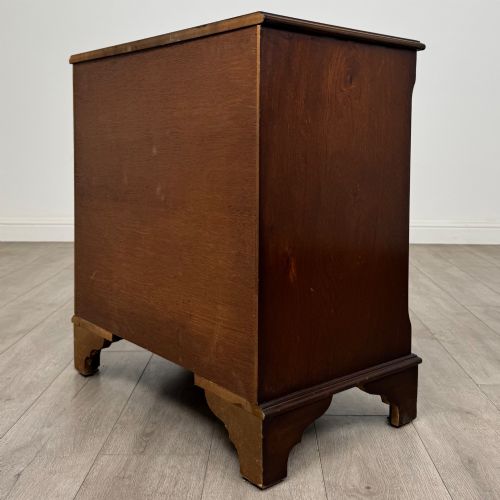fig 5. A mahogany serpentine-front chest of drawers featuring four graduated drawers with brass handles and bracket feet.