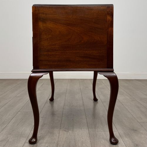 fig 2. An Edwardian mahogany writing table featuring four drawers with ornamental brass drop handles, a central kneehole aperture, and four cabriole legs.