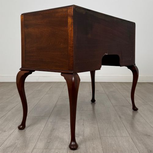 fig 3. An Edwardian mahogany writing table featuring four drawers with ornamental brass drop handles, a central kneehole aperture, and four cabriole legs.