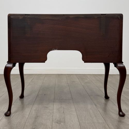 fig 4. An Edwardian mahogany writing table featuring four drawers with ornamental brass drop handles, a central kneehole aperture, and four cabriole legs.