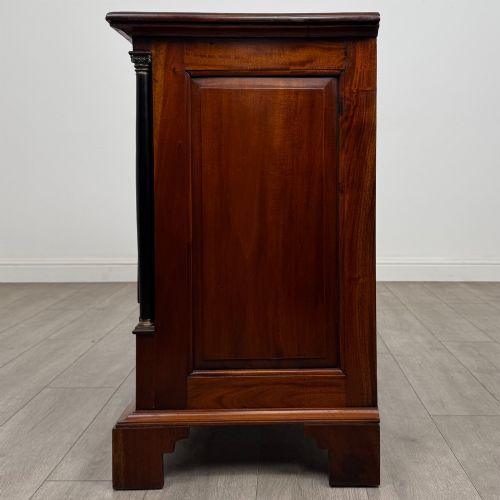 fig 2. A 20th-century Georgian style mahogany chest featuring four full-width drawers with brass drop handles, flanked by ebonised side columns, resting on bracket feet.