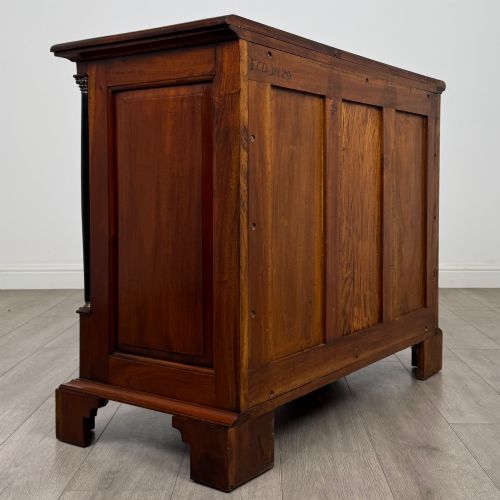 fig 3. A 20th-century Georgian style mahogany chest featuring four full-width drawers with brass drop handles, flanked by ebonised side columns, resting on bracket feet.